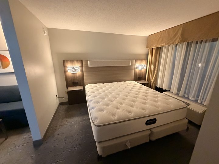 Guest room with a headboard and bedside lighting