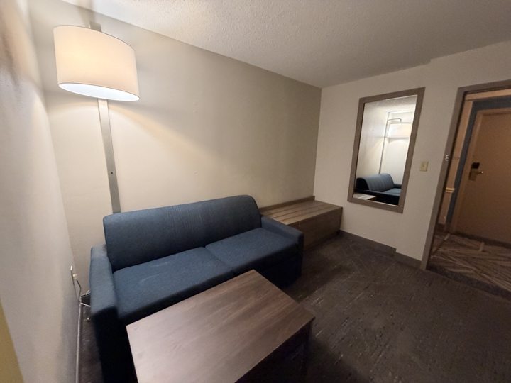 Guest suite seating area with a sofa and wall mirror