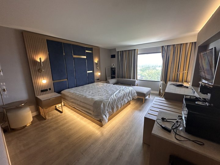 Guest room with an accent headboard wall and wood-look flooring